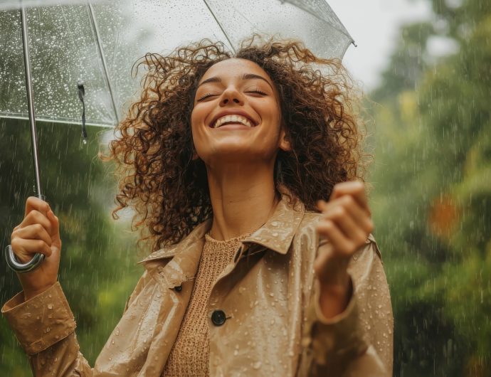Joyful Young Woman in Rainy Background Stylish Trench Nature Copyspace Viewpoint